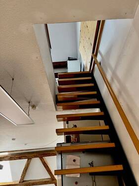 Schick eingepasst, eine schmale Treppe führt zum zweiten Dachgeschosszimmer - 