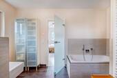 Masterbad mit Badewanne und Blick zum Schlafzimmer - 