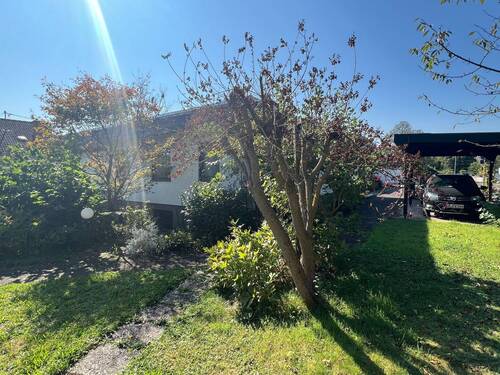 Seitenansicht Haus zum Garten mit Carport - 