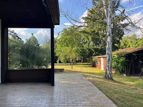Terrasse mit Blick zu Gartenhaus und Garten - 