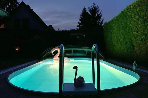 Swimmingpool mit fahrbarem Dach bei Nacht - 