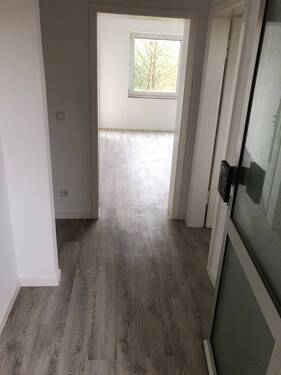 Blick von Wohnungseingangstür in Diele mit grauem PVC-Boden und tapezierfähigen Wänden von dort sieht man die Zimmereingänge mit weißen Türrahmen - 2 Zimmer Etagenwohnung zur Miete in Neuss