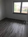 Blick in Schlafzimmer mit grauen PVC-Boden und tapezierfähigen Wänden mit weißen Fenstern - 