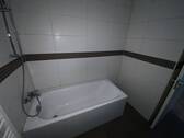  Blick in Bad mit weißen Wandfliesen, braunen Bodenfliesen, weißer Badewanne, - 