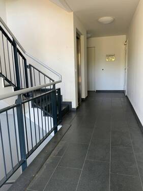 Blick Eingang in das weiße Treppenhaus grauen Treppenstufen und grauem Treppengeländer - 2 Zimmer Etagenwohnung zur Miete in Meerbusch