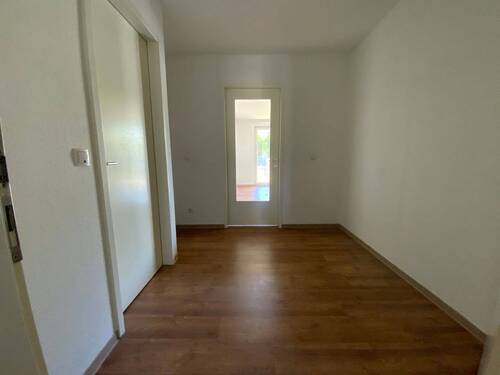 Blick Eingang in die Diele mit braunem PVC-Boden und weißen Wänden - 2 Zimmer Etagenwohnung in Meerbusch