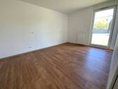 Blick von Diele in Schlafraum mit braunem PVC-Boden und weißen Wänden mit weißen ebenerdigen Fenstern - 