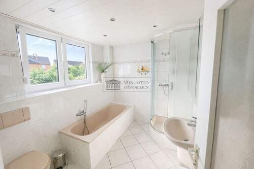 helles Badezimmer mit Badewanne und Dusche - 