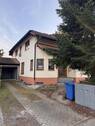 Gepflegter Hauseingang mit befestigtem Zugangsweg und integrierter Garage - 