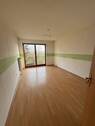 Helles Zimmer mit Balkonzugang und offener Raumgestaltung - 