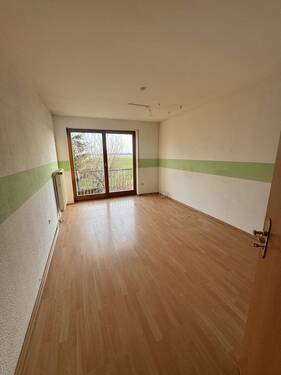 Helles Zimmer mit Balkonzugang und offener Raumgestaltung - 