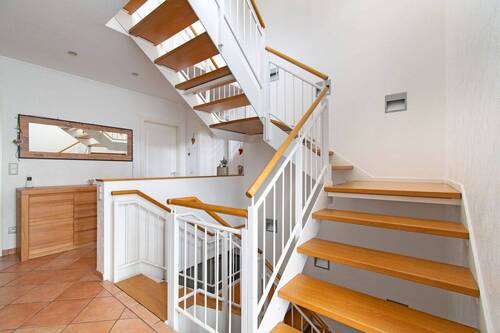 Einladender Flur mit eleganter Holztreppe - 