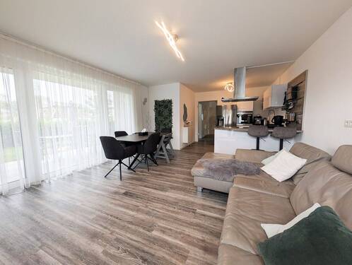 Wohnzimmer - Moderne Erdgeschosswohnung mit überdachter Terrasse und Garten