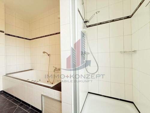 Leicht separiert das Badezimmer mit Dusche und Badewanne - 