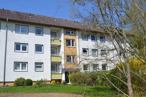 Birkenallee 97: Außenansicht auf den Eingangsbereich eines Wohngebäudes mit Satteldach. - 3 Zimmer Etagenwohnung zur Miete in Baunatal