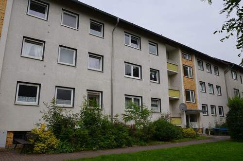 Birkenallee 95 - 99, Blick auf den Eingangsbereich mit heller Fassade und farbig abgesetzten Balkonbrüstungen - 3 Zimmer Etagenwohnung zur Miete in Baunatal