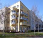 Lindenallee 13, Blick auf die hellgelbe Fassade eines mehrgeschossigen Gebäudes mit Balkonen, Erker und Gewerbeeinheiten im Erdgeschoss - Großzügige 3-Zimmerwohnung in Baunatals familienfreundlichem Stadtteil Baunsberg
