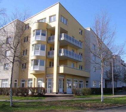 Lindenallee 13, Blick auf die hellgelbe Fassade eines mehrgeschossigen Gebäudes mit Balkonen, Erker und Gewerbeeinheiten im Erdgeschoss - Großzügige 3-Zimmerwohnung in Baunatals familienfreundlichem Stadtteil Baunsberg