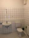 Bad (Beispiel) mit Toilette, weiße Wand- und Bodenfliesen - 