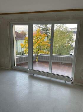 Wohnzimmer mit hellgrauem Boden und Blick auf den Balkon - 2 Zimmer Etagenwohnung zur Miete in Bad Nauheim