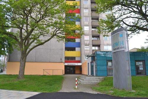 Heinrich-Nordhoff-Str. 8: Blick auf den Eingangsbereich eines Hochhauses und GWH-Büro - 1 Zimmer Etagenwohnung zur Miete in Baunatal