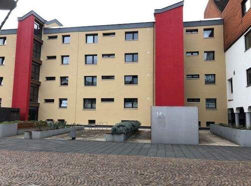 An der Stadthalle 14 Blick von Straße auf den Eingangsbereich eines mehrgeschossigen Wohngebäudes mit Flachdach - Großzügige 3-Zimmerwohnung in energetisch saniertem Gebäude in Altenbauna-Innenstadt