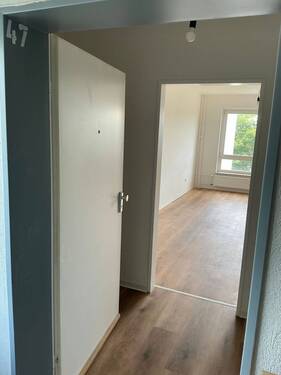 Flur mit neuem Fußbodenbelag in Holzoptik, Wände tapeziert und weiß angelegt - 