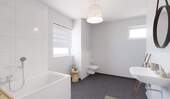 Modern gefliestes Tageslichtbad mit Badewanne und - 