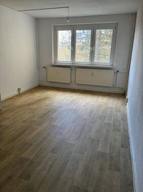 Wohnzimmer (Musterbild) - Familienfreundliche Wohnung mit offener Küche und Spielplatz im Innenhof