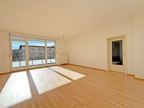 Wohnzimmer mit hellem Parkettboden und Balkonzugang - 2 Zimmer Einfamilienhaus in München