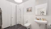 Ein modern gefliestes Badezimmer mit bodengleicher - 