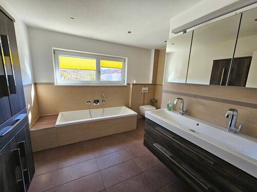 Badezimmer mit Wanne und Fenster - 