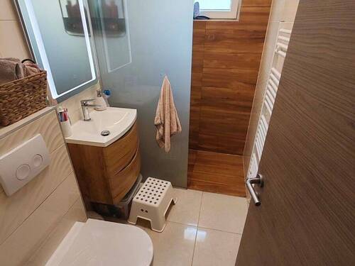 Badezimmer mit bodentiefer Dusche in Holzoptik - 