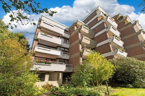 Modernes Wohnhaus mit großzügigen Balkonen und grüner Umgebung - 