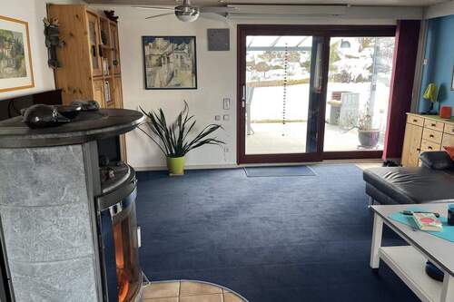 Wohnzimmer mit Kaminofen und Ausgang zur Terrasse - 