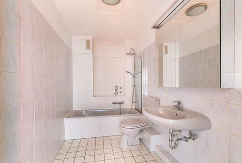Zeitlos gefliestes Badezimmer mit komfortabler Badewanne - 