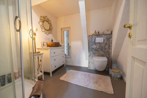 Badezimmer mit eleganten Armaturen und bodentiefer - 