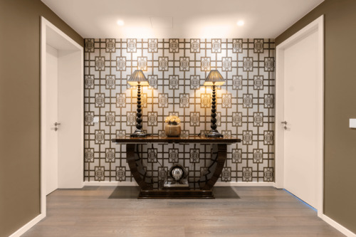 Repräsentativer Eingangsbereich mit Art-déco-Konsole und goldener Mustertapete - 