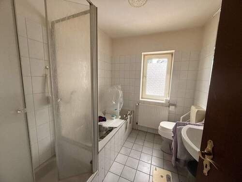 Badezimmer mit Badewanne, Dusche und Fenster - 