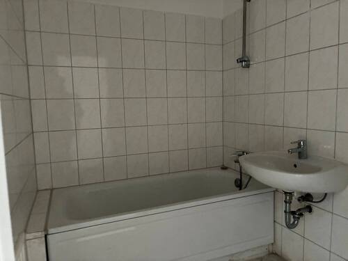 Bad mit Badewanne, weißem Waschbecken und weißen Fliesen - Etagenwohnung mit 87,20 m² in Darmstadt zur Miete