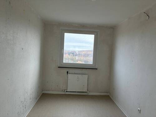 Ansicht des halben Zimmers mit tapetenfreien Wänden und hellem Linoleumboden - 