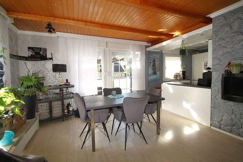 Das Wohnzimmer mit Zugang zur offenen Einbauküche - 