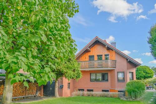 Blick aus dem Garten - Ruhepol am Feldrand: Stilvolles Einfamilienhaus mit Garage