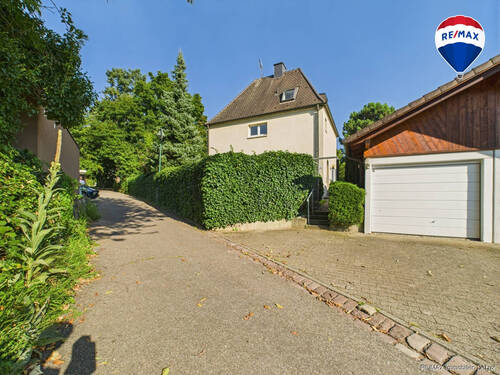 RE/MAX Immobilien DeLux Einfamilienhaus Freiburg Rückansicht mit Garage - 5 Zimmer Einfamilienhaus zum Kaufen in Freiburg im Breisgau / Herdern