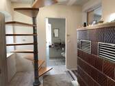 Flur mit Kachelofen und Treppe ins OG - 