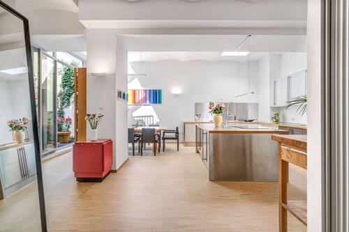 Lichtdurchflutetes Esszimmer mit offen gestalteter Küche. - Lichtdurchflutete Gartenwohnung im Loft-Stil. Ruhige, grüne Innenhoflage.