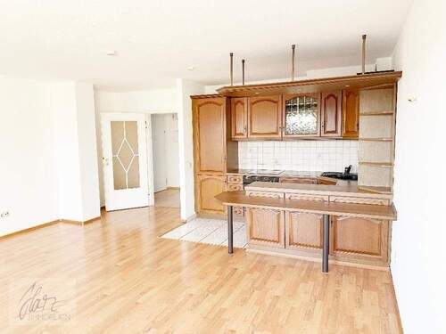 Wohnzimmer mit Blick Richtung Küche und Flurbereich - 