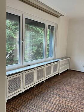 Lichtdurchflutetes Ambiente: Stilvolle Heizkörperverkleidung mit elegantem Sichtschutz und Panoramablick ins Grüne - 