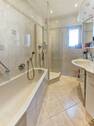 Badezimmer mit Wanne und Dusche im EG - 