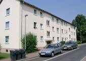 Vorderansicht auf das dreistöckige Mehrfamilienhaus mit einem Parkstreifen und Sträuchern vor der Tür - 2 Zimmer Etagenwohnung zur Miete in Bad Hersfeld